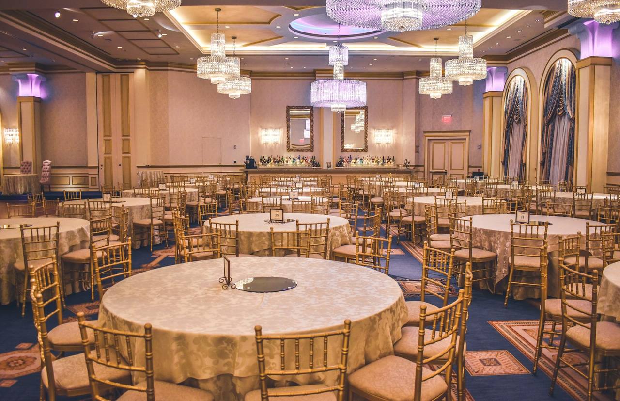 Salle de réception aux lustres cristallins préparée pour un grand dîner — photo d’ambiance